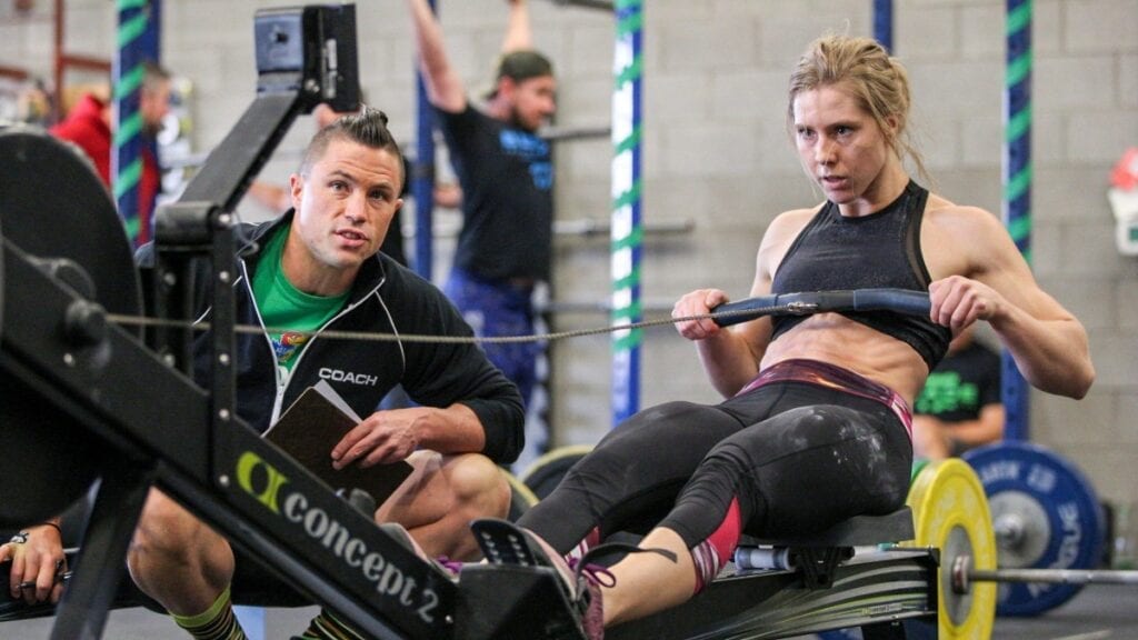 coach oversees athlete rowing