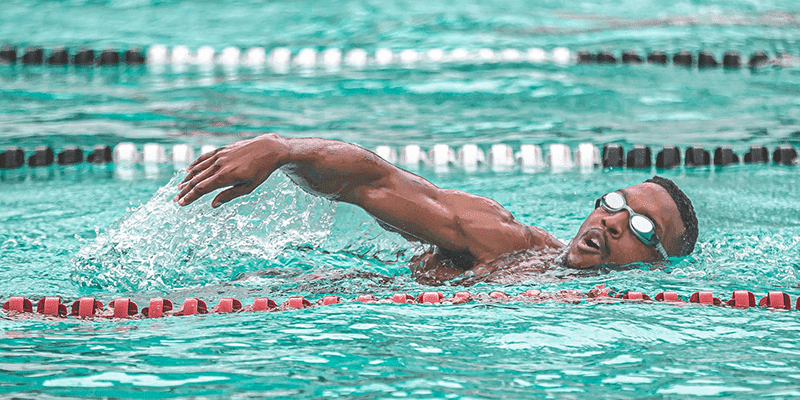 Swimming man in pool with goggles